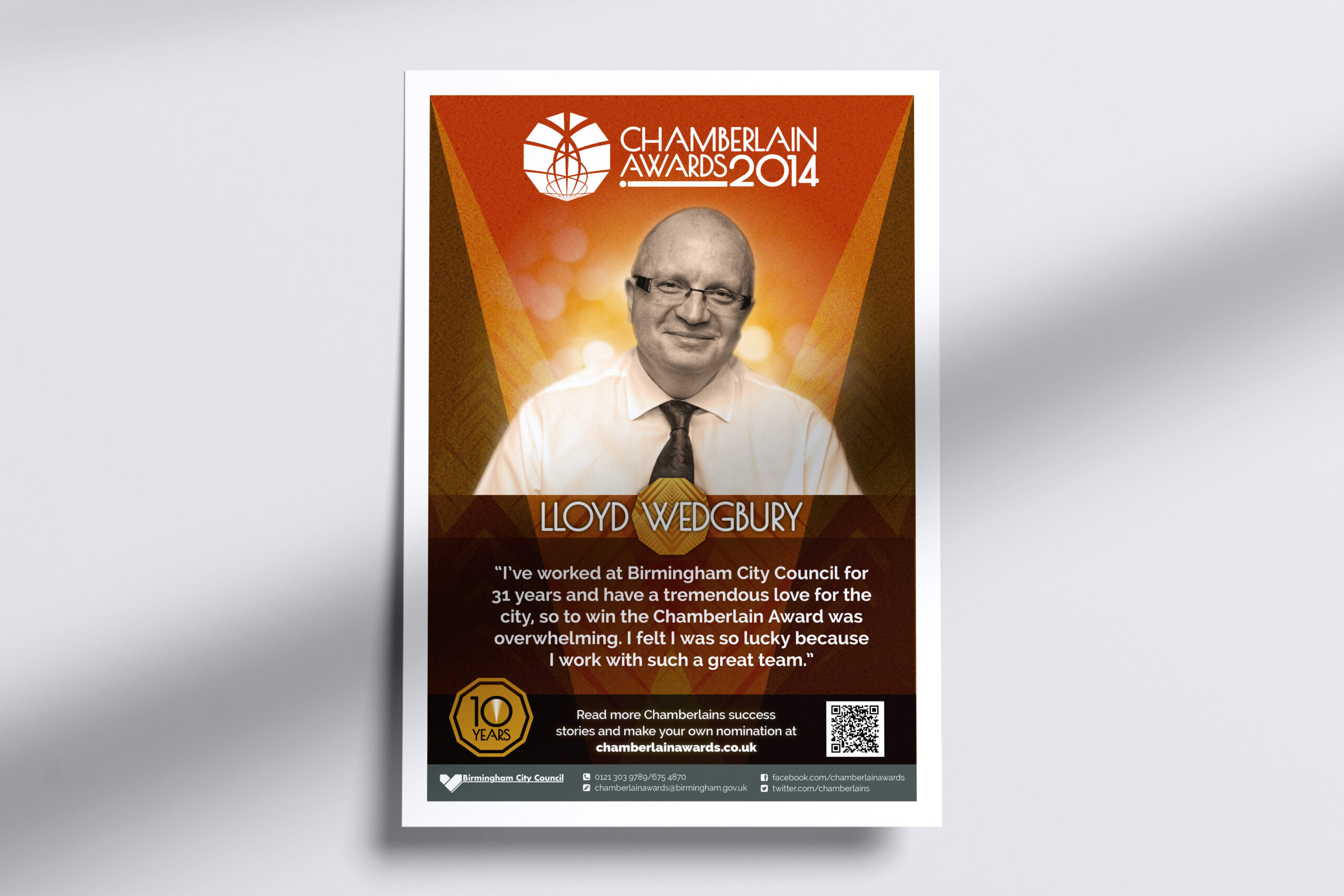 A promotional poster for the 2014 Chamberlain Awards is shown on a light-coloured wall. The poster shows an image and quote from previous award winner Lloyd Wedgbury
