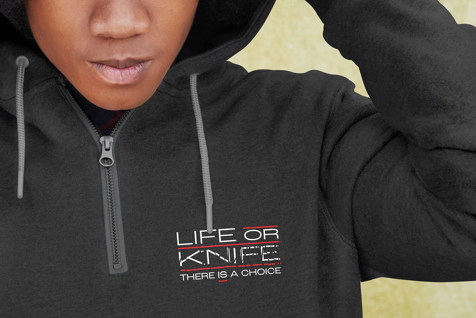 Close-cropped image of a young person wearing a Life or Knife branded hoodie